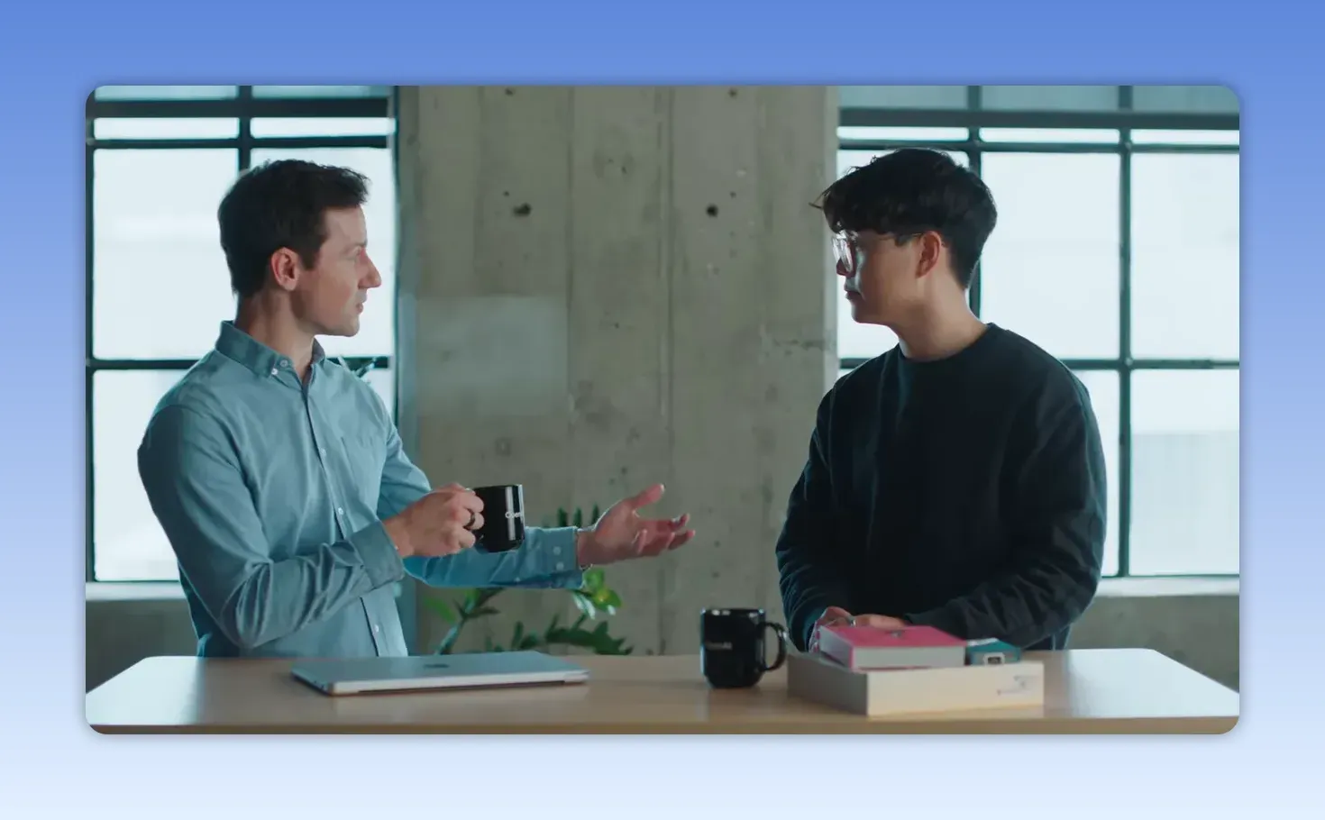 ภาพการสนทนาในห้องทำงานโดยมีผู้ร่วมประชุมสองคนคุยกันต่อหน้าโต๊ะ